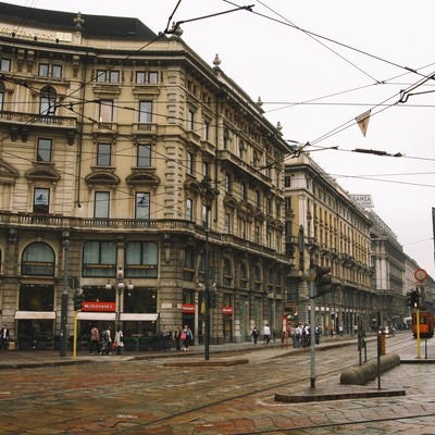 ミラノの通りと共に張りめぐる電線と街並み（イタリア）の写真
