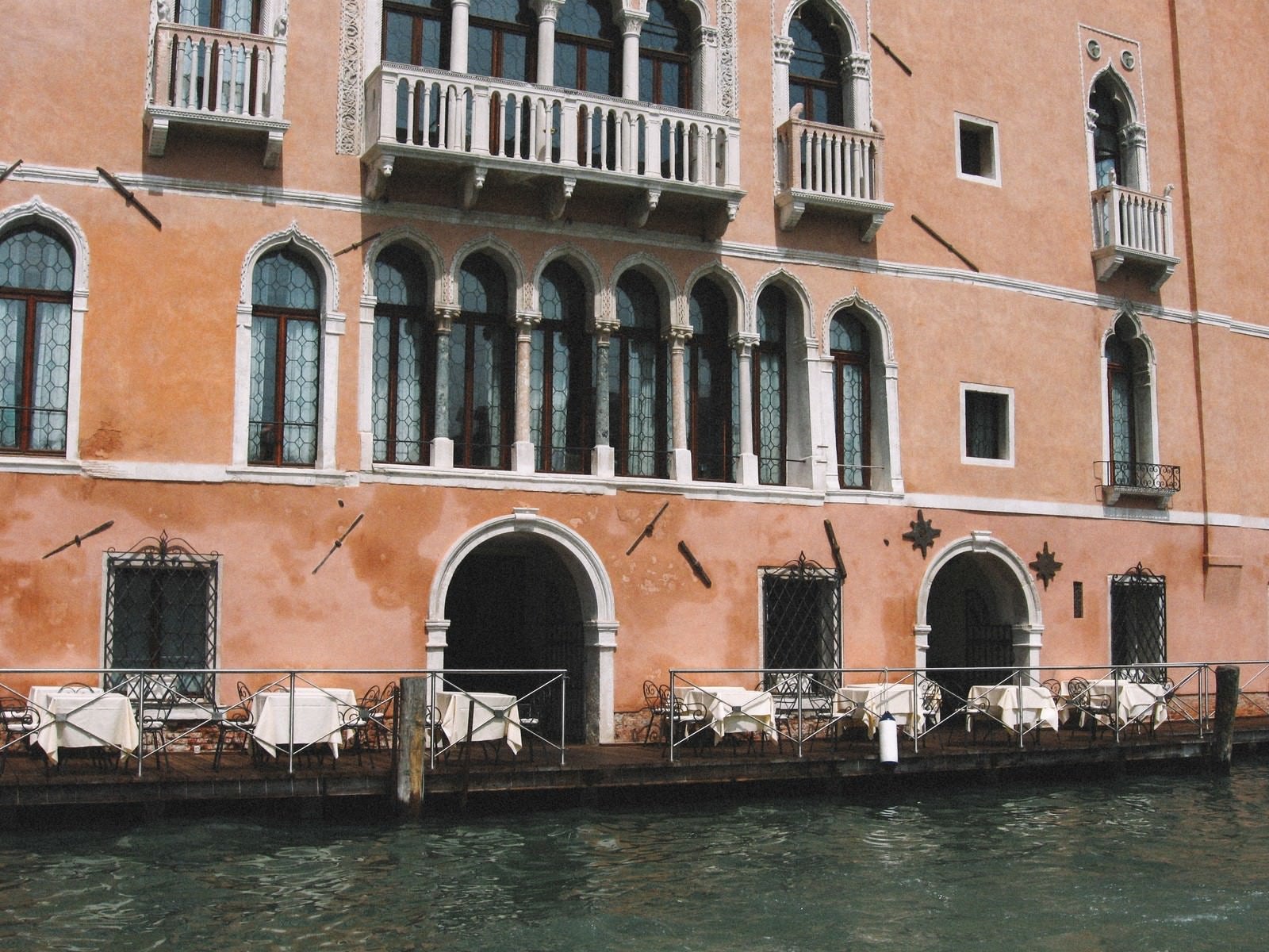 「ヴェネツィアの川沿いにあるレストランの白いテーブル（イタリア）」の写真
