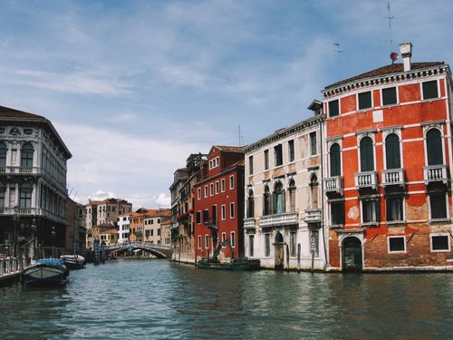 ヴェネツィアにある川に浮かぶ小船と街並み（イタリア）の写真