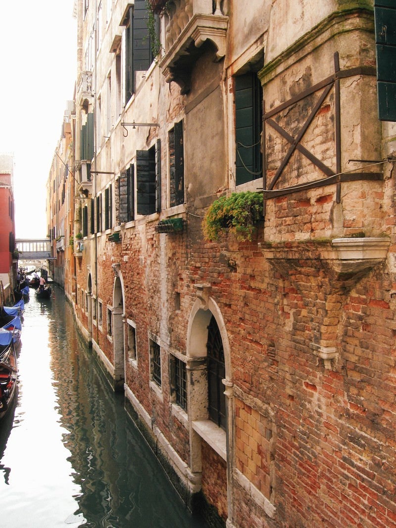 「ヴェネツィアの水路に浮かぶゴンドラとレンガ造りの建物（イタリア）」の写真