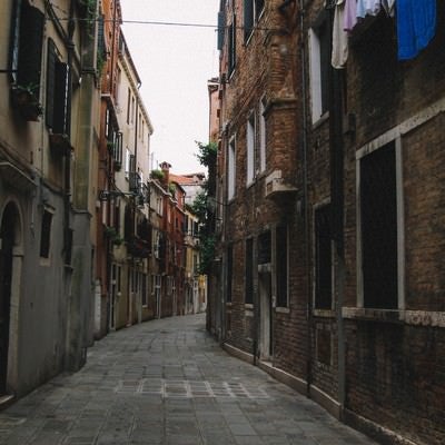 ヴェネツィアのレンガ造りの建物に囲まれる路地裏（イタリア）の写真