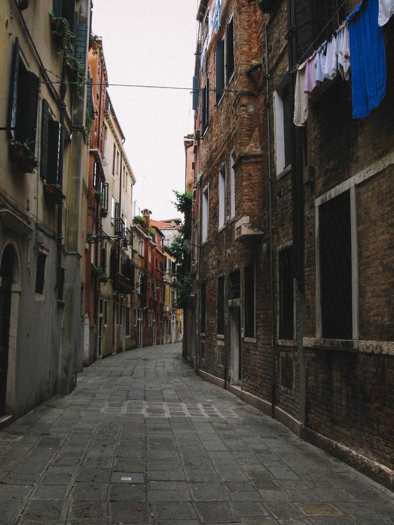 「ヴェネツィアのレンガ造りの建物に囲まれる路地裏（イタリア）」の写真