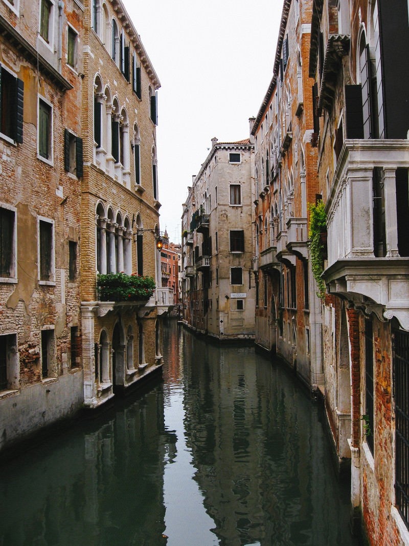 「レンガ造りの建物沿いを流れるヴェネツィアの水路（イタリア）」の写真