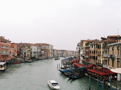 ヴェネツィアを流れる水路の船着場と浮かぶゴンドラ（イタリア）の写真