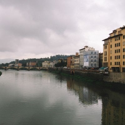 フィレンツェを流れる川と遠くに見える橋（イタリア）の写真