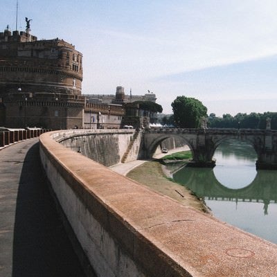 ローマにあるサンタジェロ城に続く道と川に架かる橋（イタリア）の写真