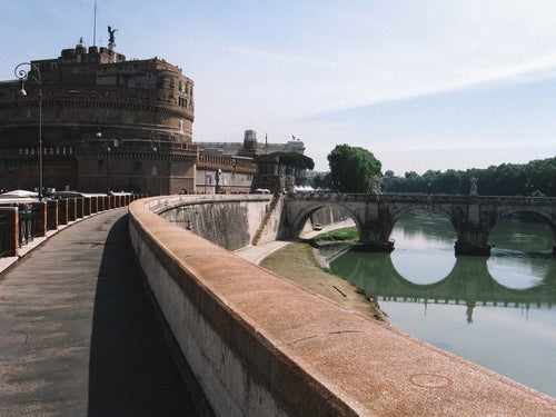 ローマにあるサンタジェロ城に続く道と川に架かる橋（イタリア）の写真