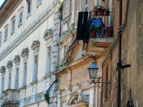 オルヴィエートの出窓に並ぶ花と洗濯物（イタリア）の写真