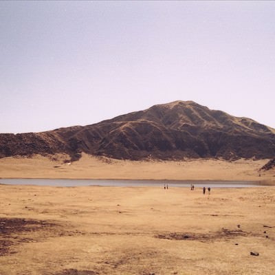 麓の湖畔に集まる観光客の写真