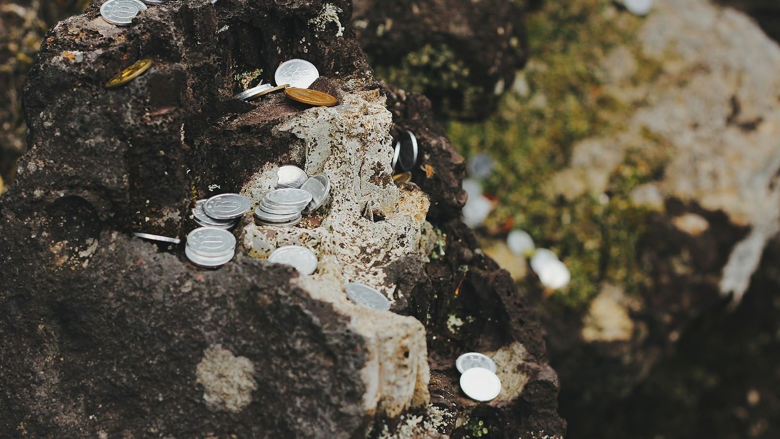 「岩場に置かれた小銭」の写真