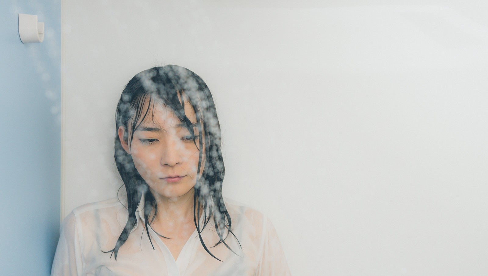 「シャワーで涙を流す失恋女子」の写真［モデル：たけべともこ］