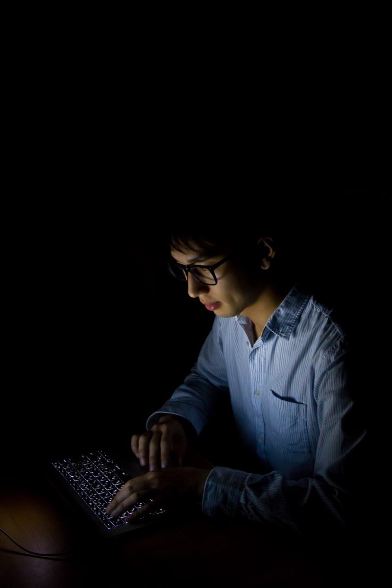 「暗闇でPCを使う男性」の写真［モデル：大川竜弥］