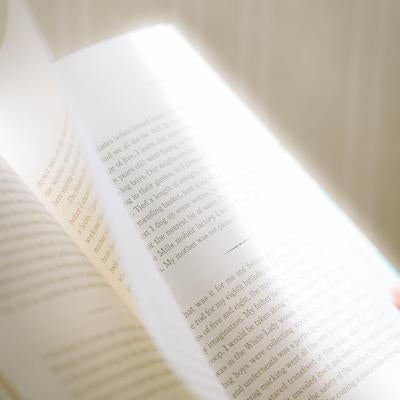 洋書のページをめくる手元の写真