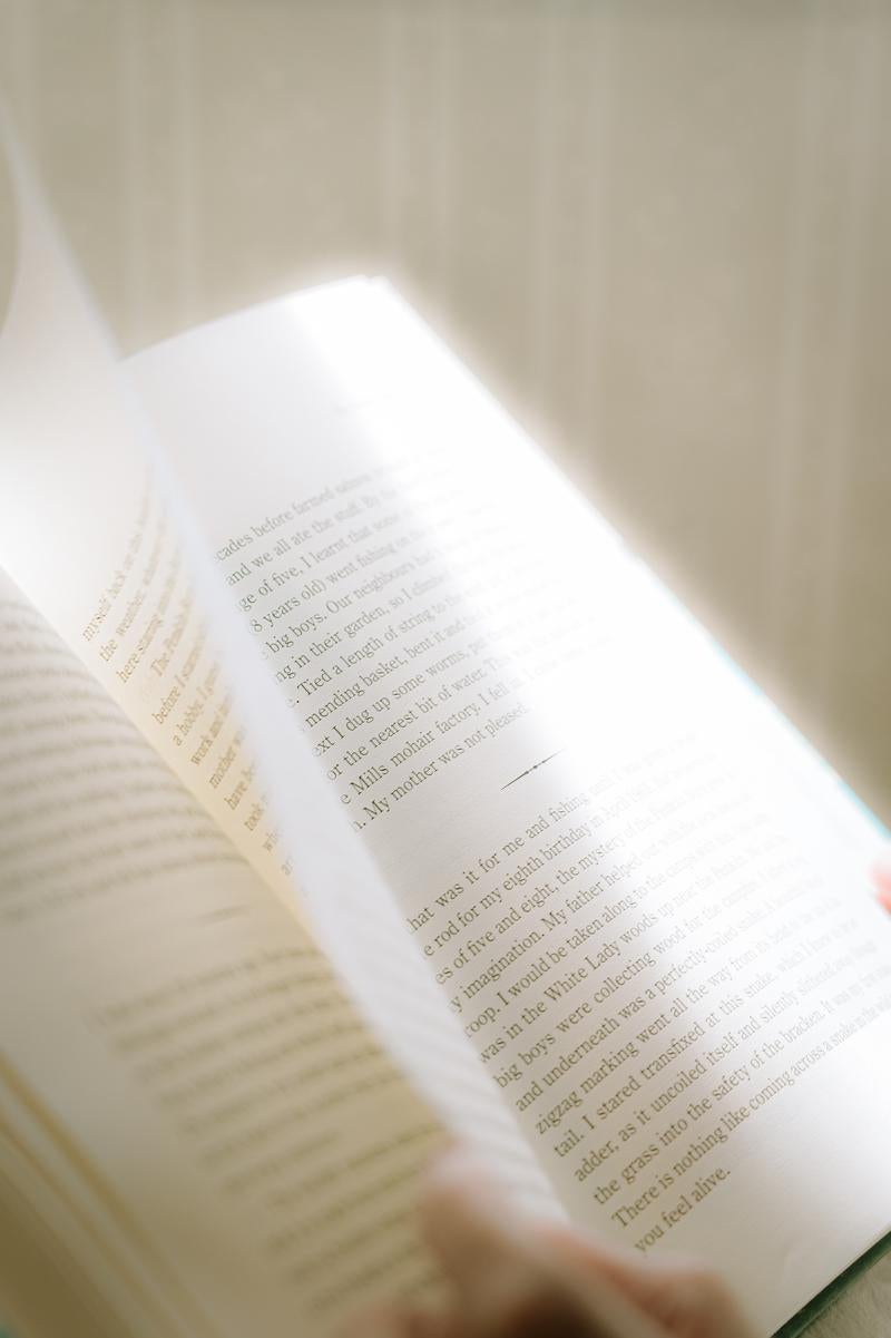 洋書のページをめくる手元の写真