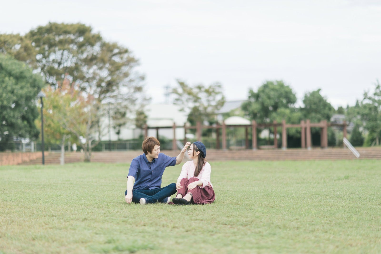 「大刀洗公園の芝の上で休日デートする夫婦」の写真［モデル：五十嵐夫妻］