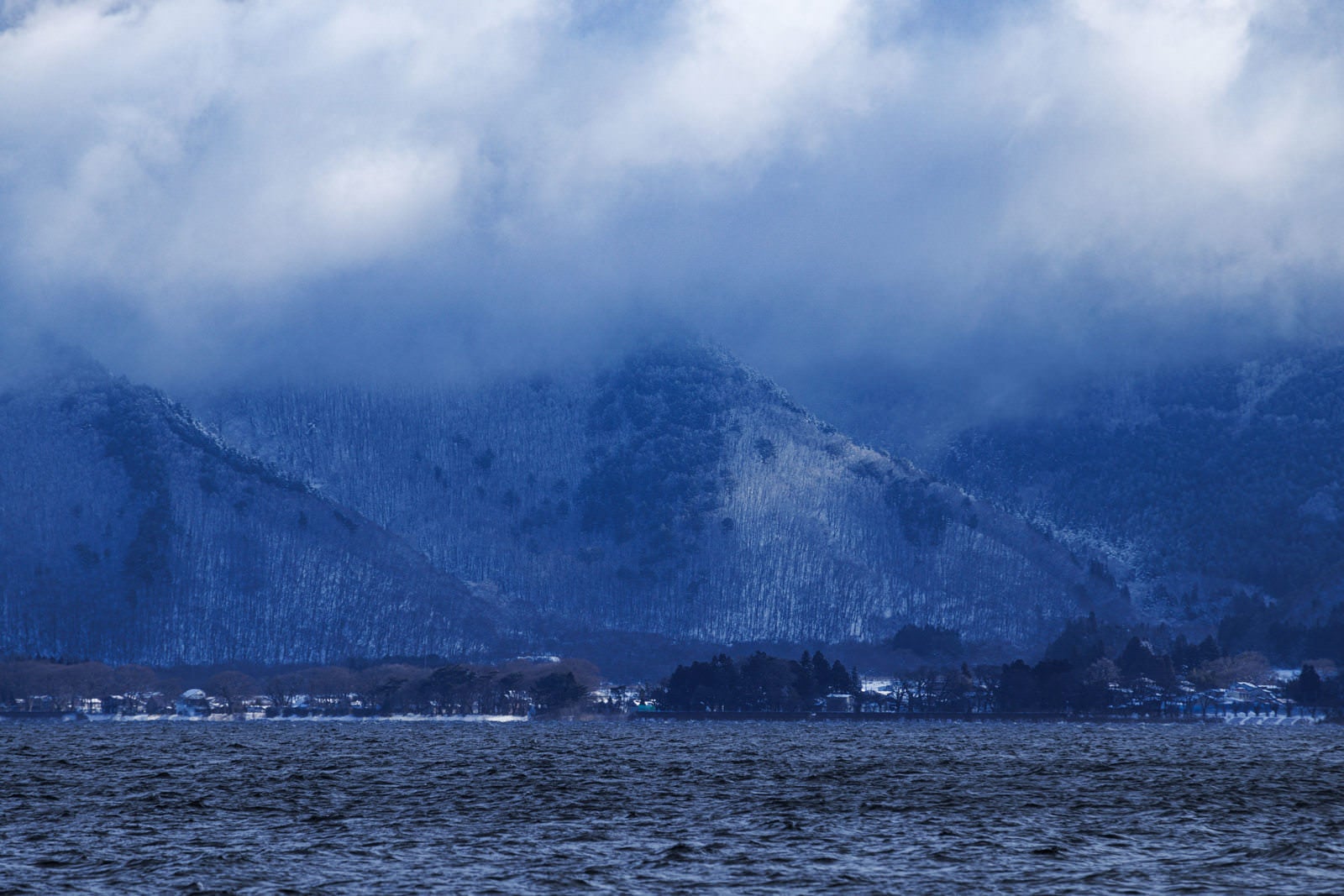 「雪化粧した山と猪苗代湖」の写真
