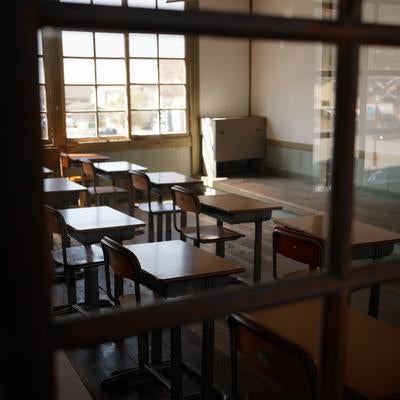 窓ガラスに反射する風景と教室の写真