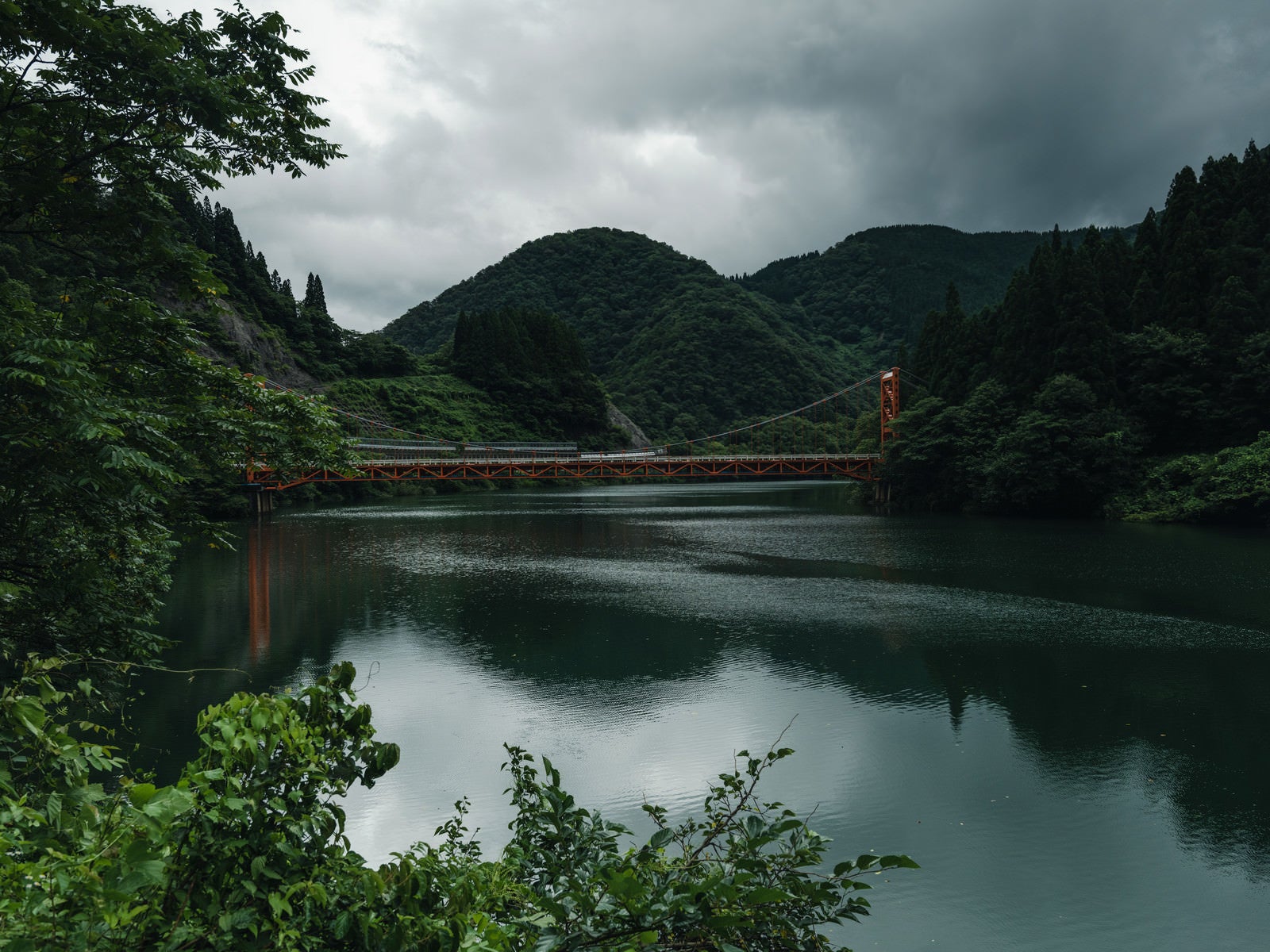 「庄川峡の水面に映りこむ橋（富山県南砺市）」の写真
