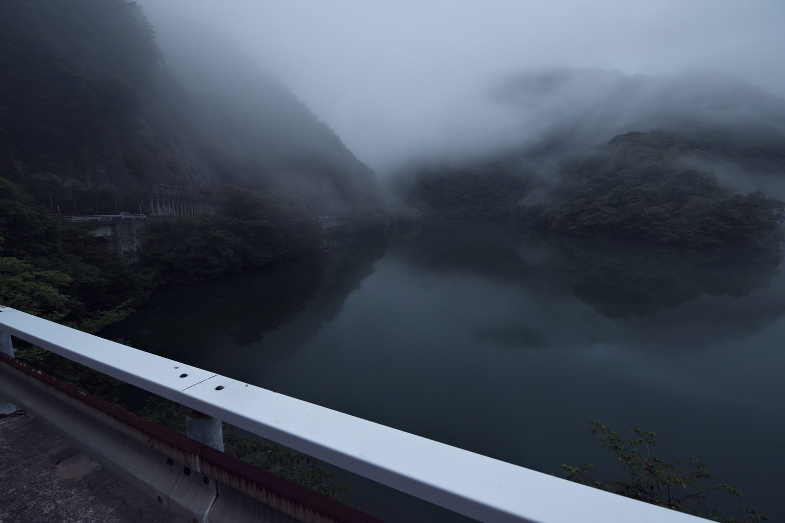 「霧に覆われる山と湖面（富山県南砺市）」の写真