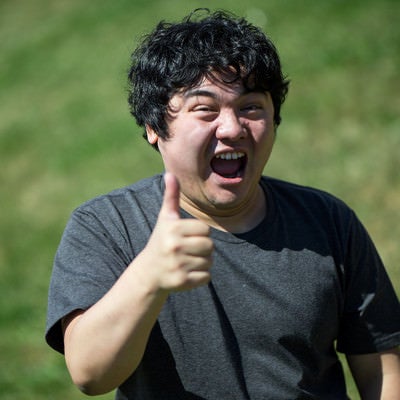 笑顔でサムズアップする男性の写真