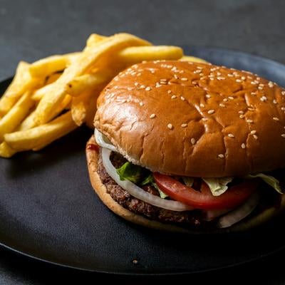 ゴマ付きバンズのハンバーガーとフライドポテトセットの写真