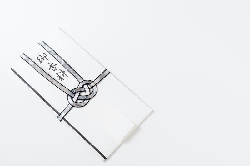 御香典と書かれた白い不祝儀袋と黒白の水引結び切りの写真