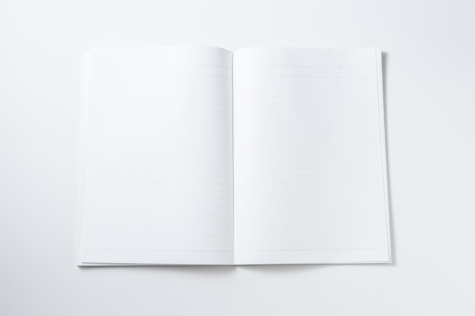 白い背景に置かれた真っ白な見開きノート、何も書かれていない状態