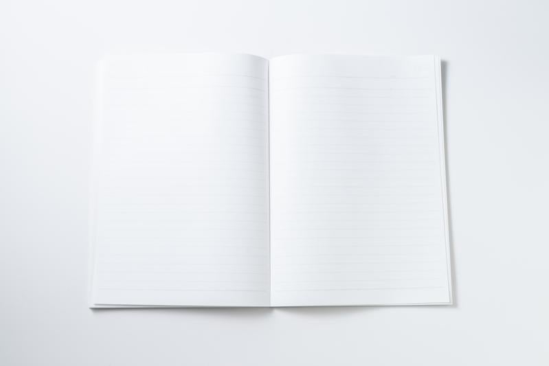 何も書かれていない真っ白な見開きノートと文具の背景デザインの写真