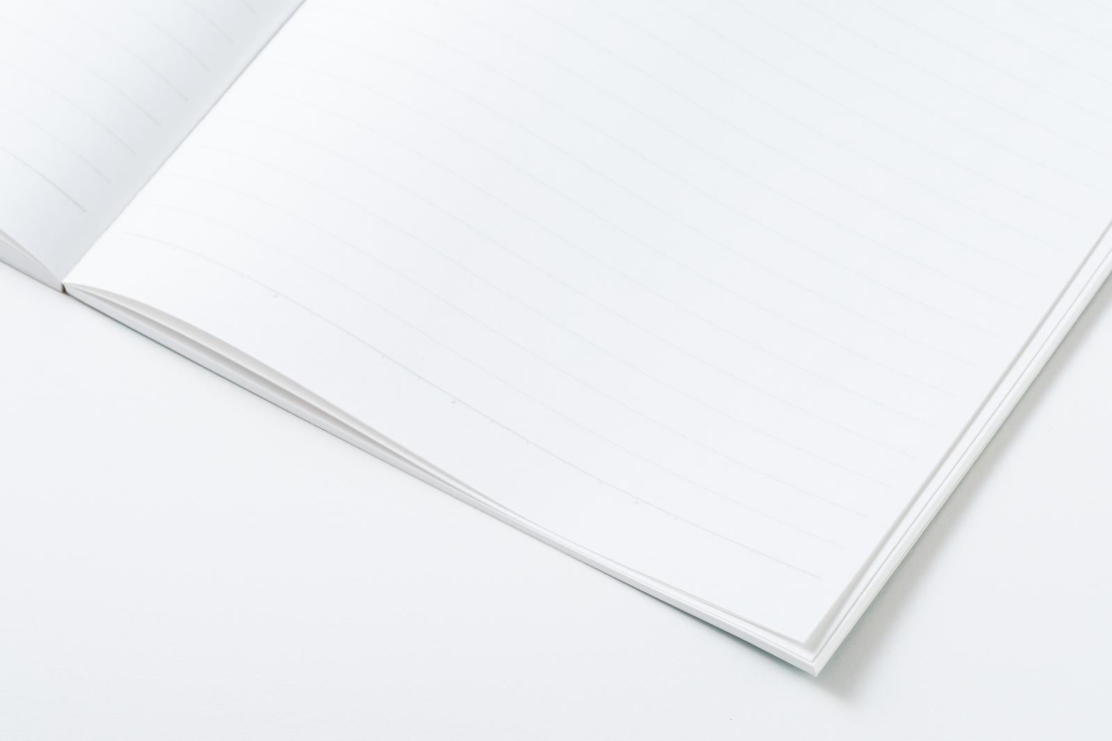 白い背景に置かれた開かれたノート、無地の真っ白なページが見開きになっている