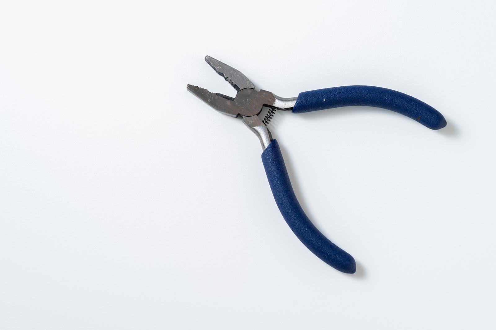 白背景に青いグリップ付きのニードルノーズプライヤーを配置した工具写真