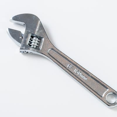 白背景に置かれたシルバーのモンキーレンチの写真