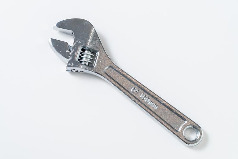白背景に置かれたシルバーのモンキーレンチの写真