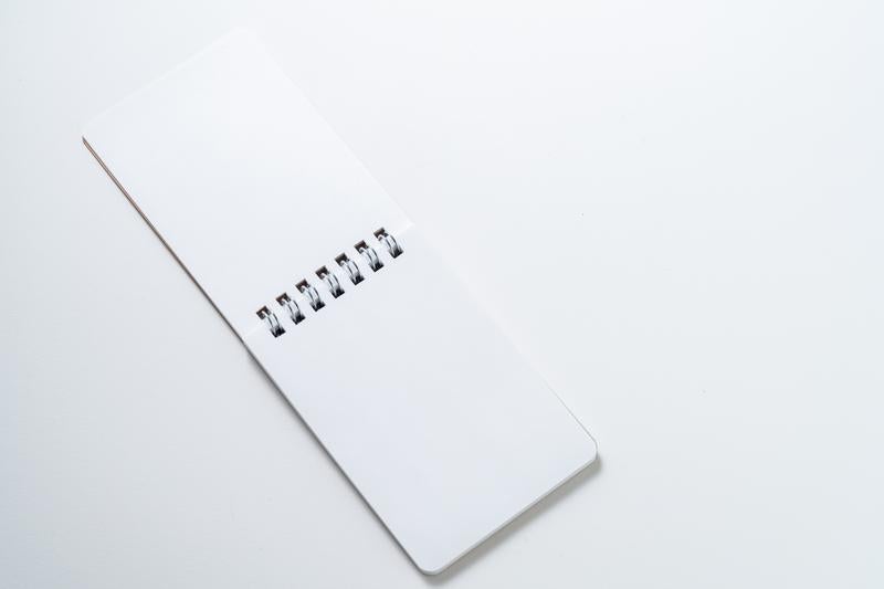 クラフト紙のリングノートと清潔な白背景の文具