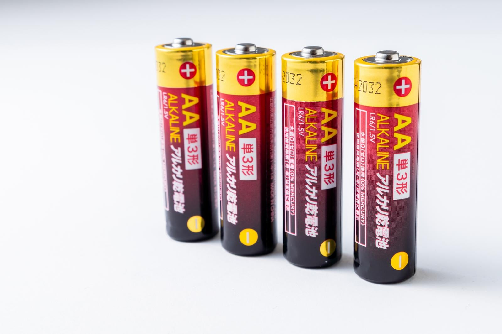 白い背景に4本の単三アルカリ乾電池が横一列に並んでいる