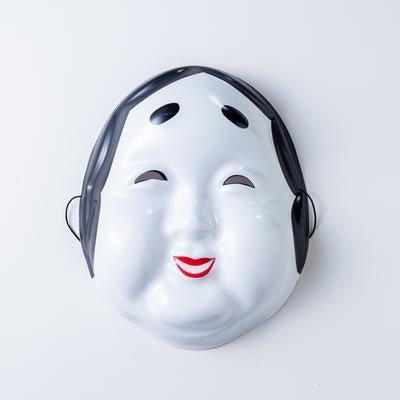 微笑む表情の白いおたふくお面の写真