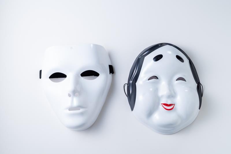 対照的な表情の白いお面の写真