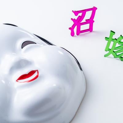 笑顔のおたふく面と無表情の白いお面の対比の写真