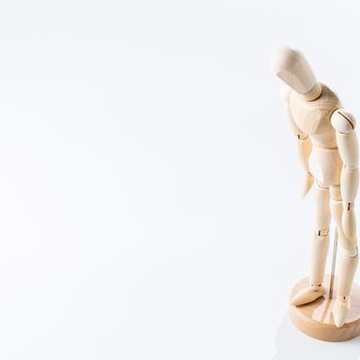 右手を上げるポーズの木製デッサン人形の写真