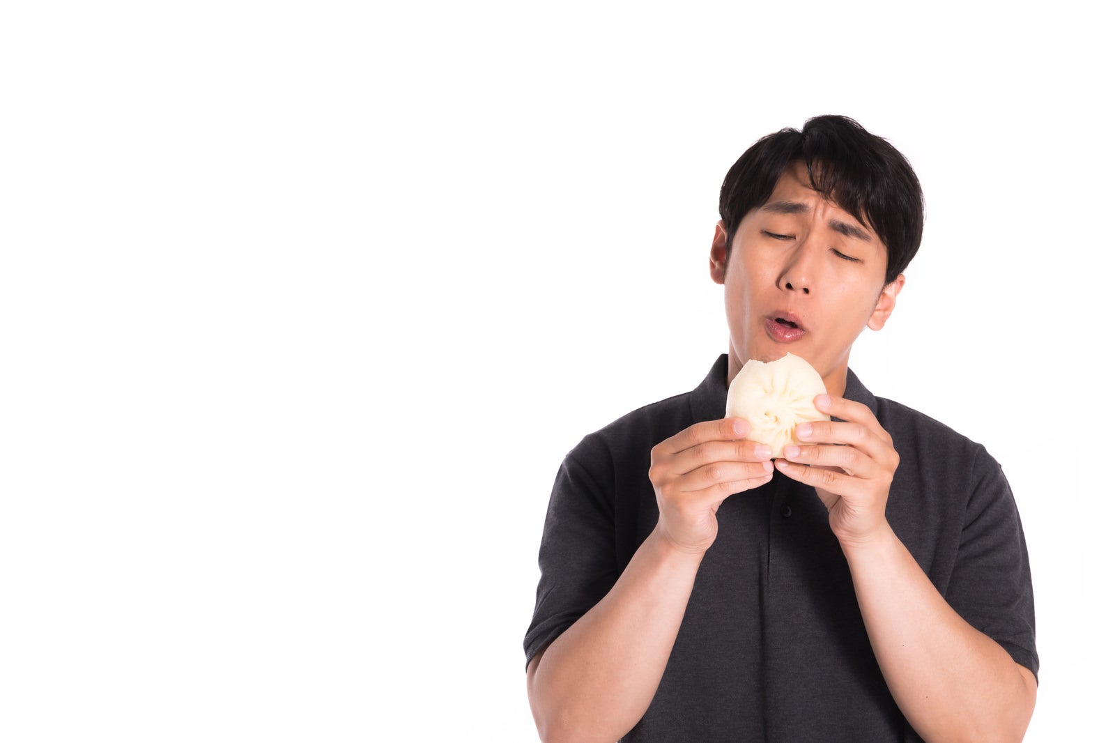 「豚まんを食べる男性」の写真［モデル：大川竜弥］