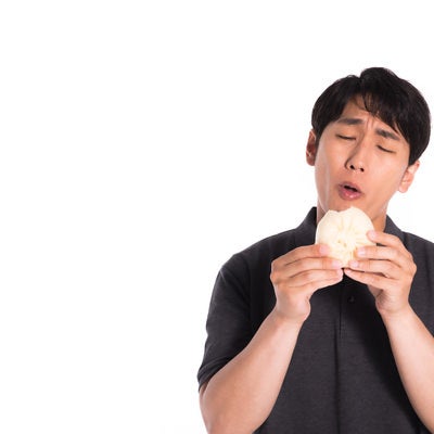 豚まんを食べる男性の写真