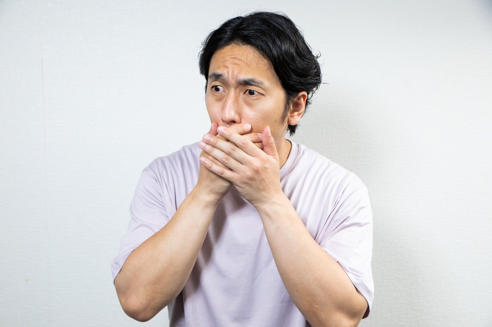 「驚愕して口を覆う男性」の写真［モデル：大川竜弥］