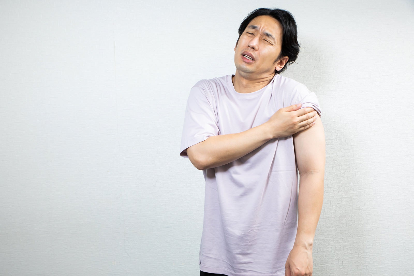 「注射後に腕を抑える男性」の写真［モデル：大川竜弥］