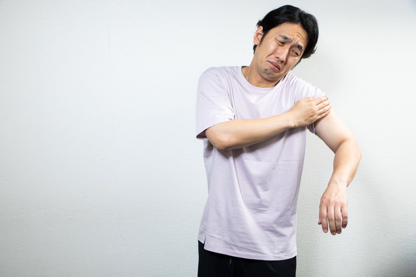 「ワクチン接種の痛みに顔を歪める男性」の写真［モデル：大川竜弥］