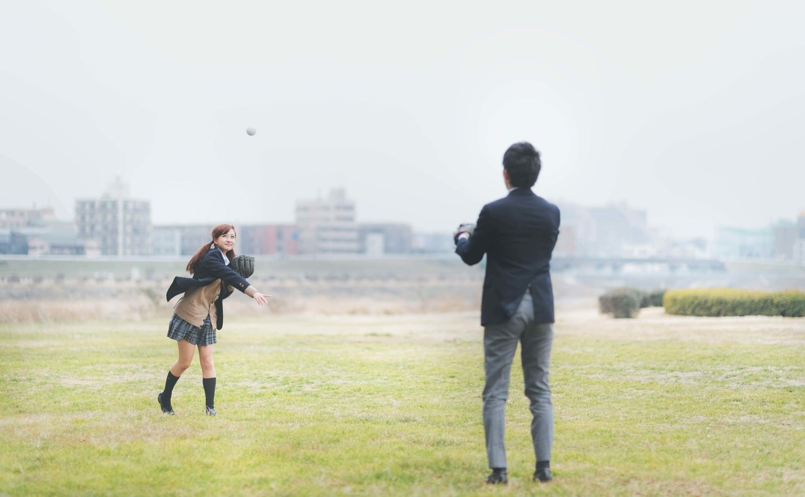 「放課後に彼氏とキャッチボールする女子高生」の写真［モデル：河村友歌］