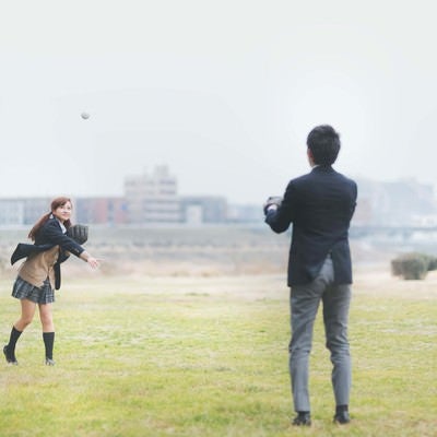 放課後に彼氏とキャッチボールする女子高生の写真