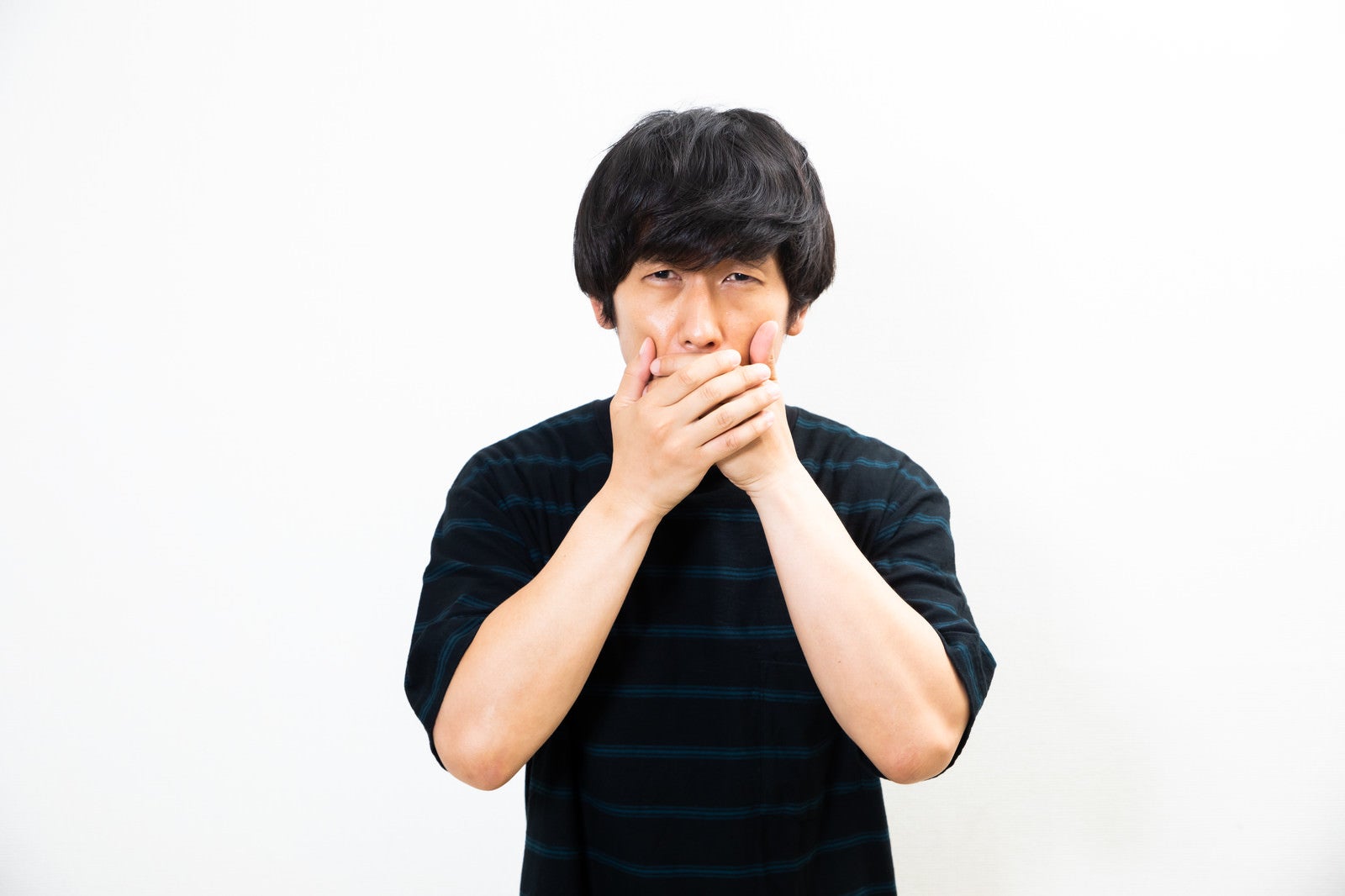 「息苦しさに口を覆う男性」の写真［モデル：大川竜弥］