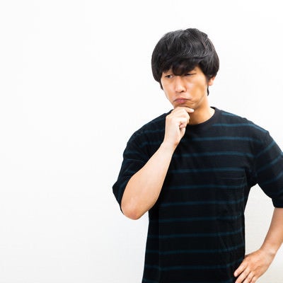 顎に手を当てて考える男性の写真