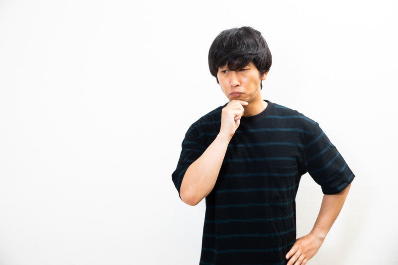 顎に手を当てて考える男性の写真