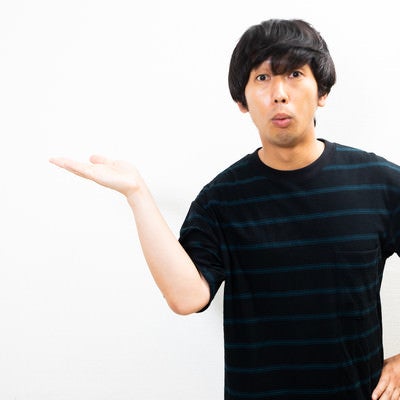 口をすぼめて説明する男性の写真