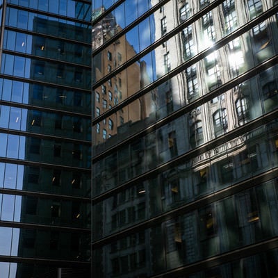 高層ビルのガラス窓に反射する街並み（ニューヨーク）の写真